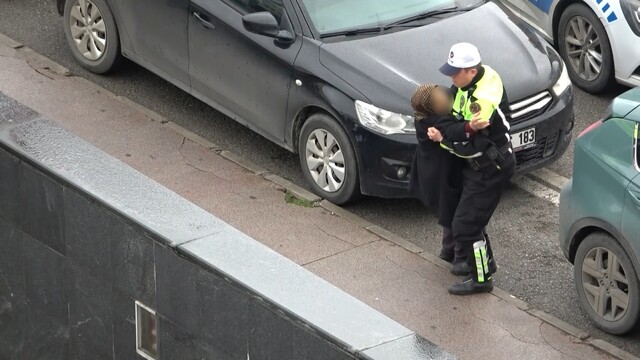 Kaldırıma taşıyan polis, yaralı kadını ıslanmaktan korudu